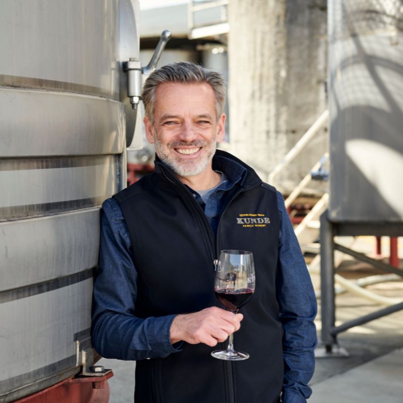 Winemaker with wine barrels.