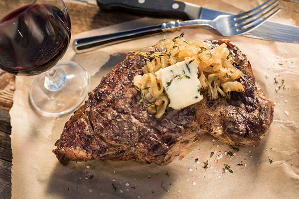 Grilled Rib Eye Steaks with Caramelized Onions and Blue Cheese