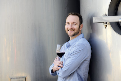 Virtual Tastings: Man showcasing wine in box.