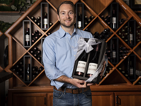 Virtual Tastings: Man showcasing wine in box.